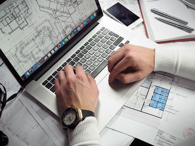 Un homme travaille sur le plan d'une maison sur un portable.